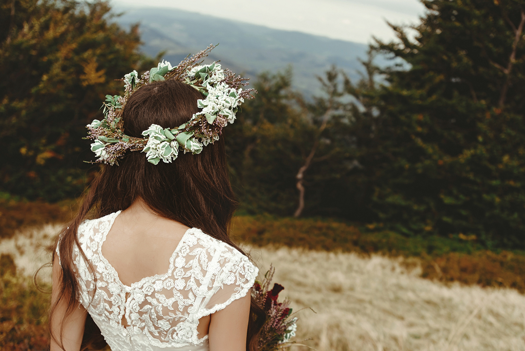 stylish bride posing with bouquet on background of forest, luxury boho wedding at mountains